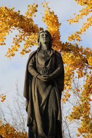 A statue under yellow ginkgo leaves at The Woodlands
