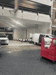 A row of small white sidewalk delivery robots parked and charging in a garage