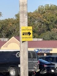 A yellow CREW PARKING sign on a utility pole in Folcroft