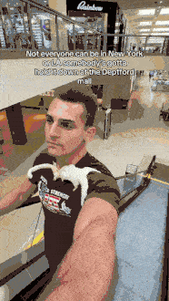 A man films himself riding a mall escalator and walking past storefronts with a white ferret perched on his shoulder, under the on-screen line about holding it