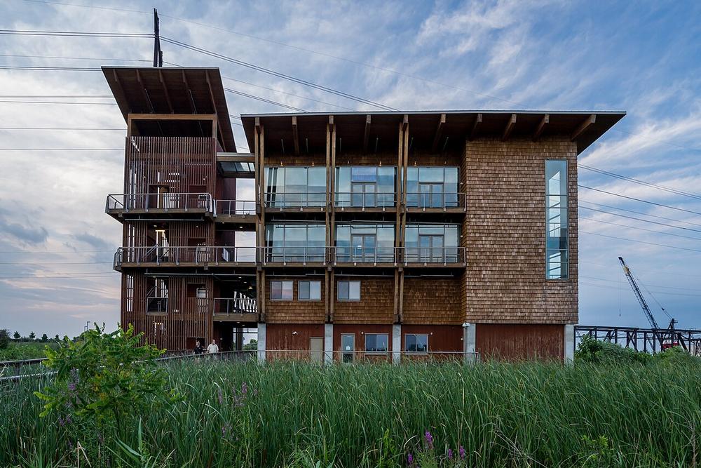 The DuPont Environmental Education Center, a four-story wood and glass building at the edge of the marsh