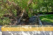 Bozeman Creek running past a mosaic wall reading More Precious Than