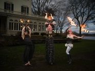 Three fire performers on the lawn in front of Glen Foerd's mansion at a past Masquerade Ball