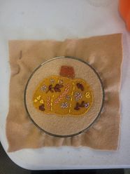An embroidered pumpkin in a wooden hoop